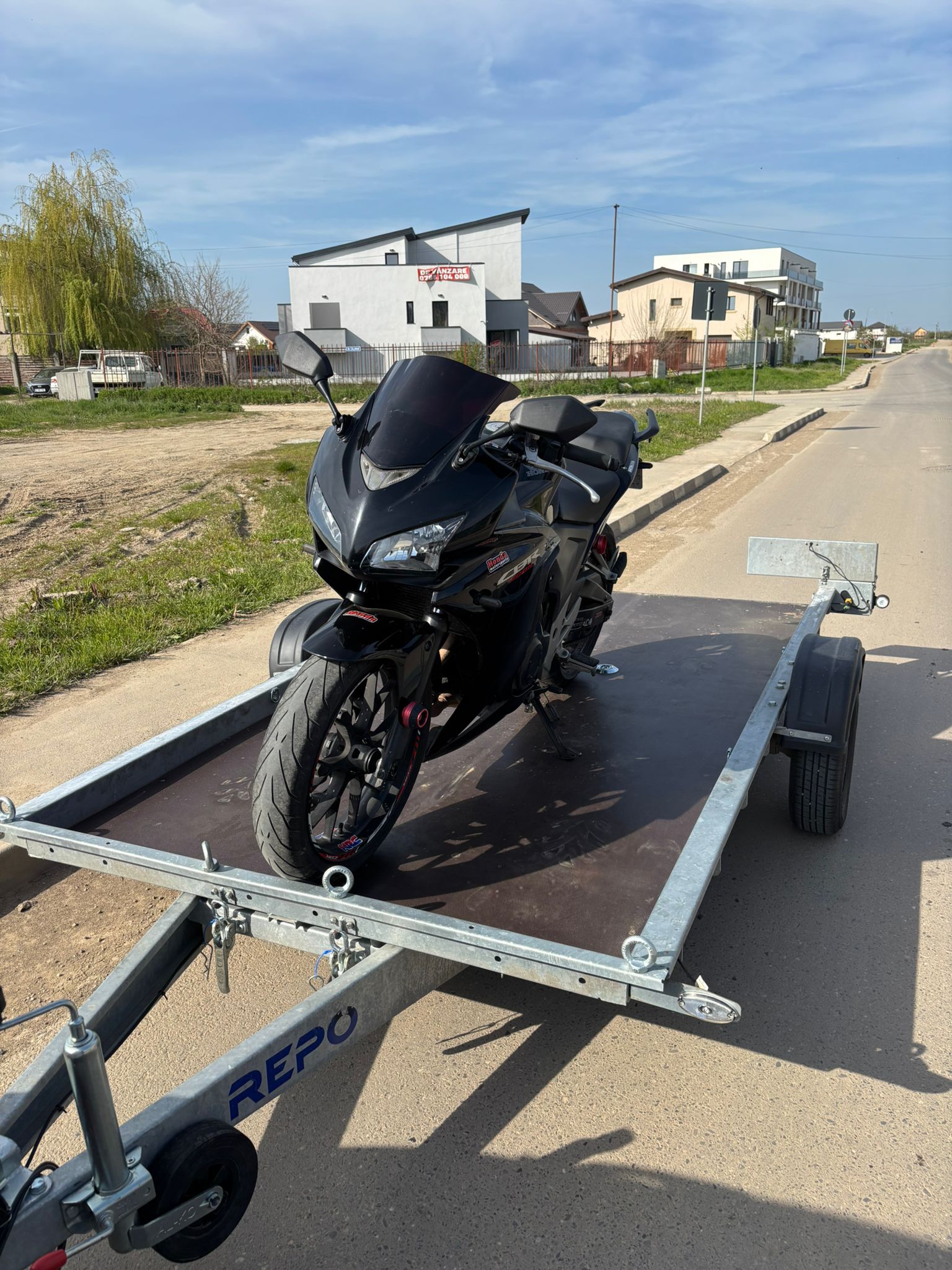 Honda CBR neagră fixată pentru transport cu platformă dedicată moto