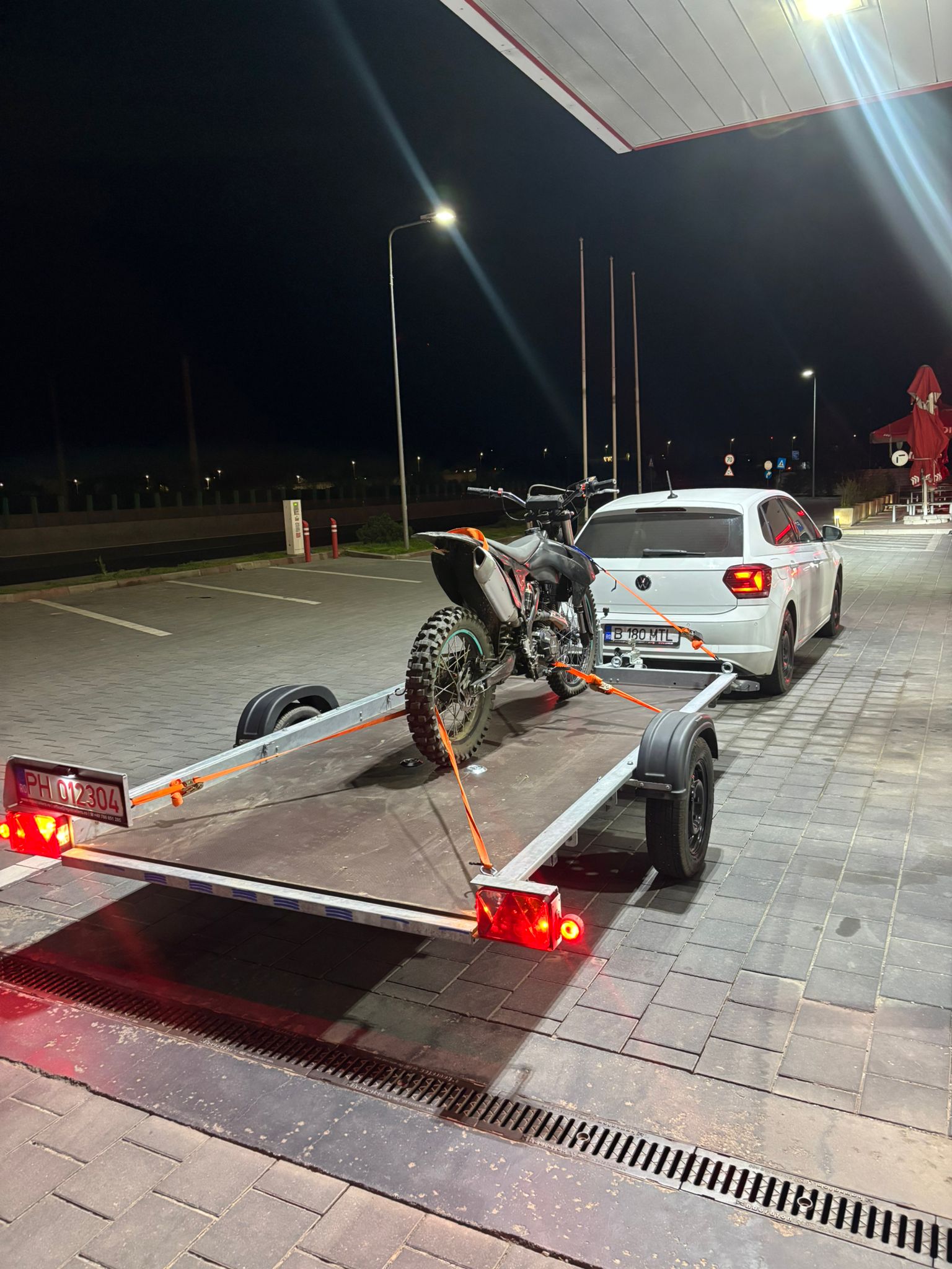 Intervenție nocturnă, tractare motocicletă enduro pe platformă iluminată